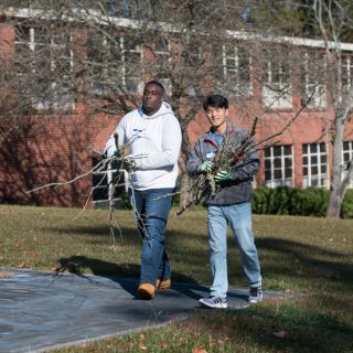 students help gather debris around a school. 