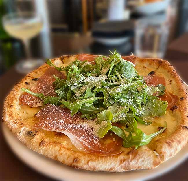 A closeup photo of a whole pizza on a plate.