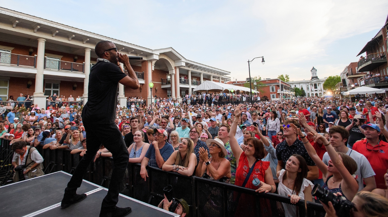 Musician performs to crowd at festival.