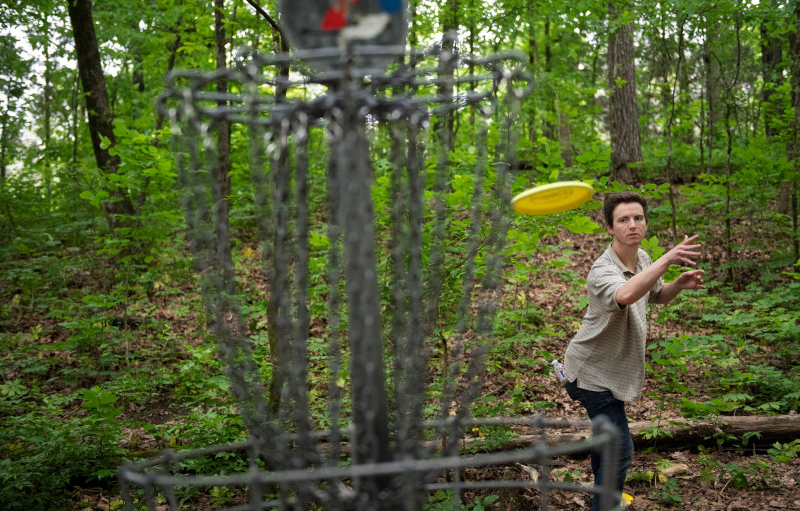 male student frisbee golfing